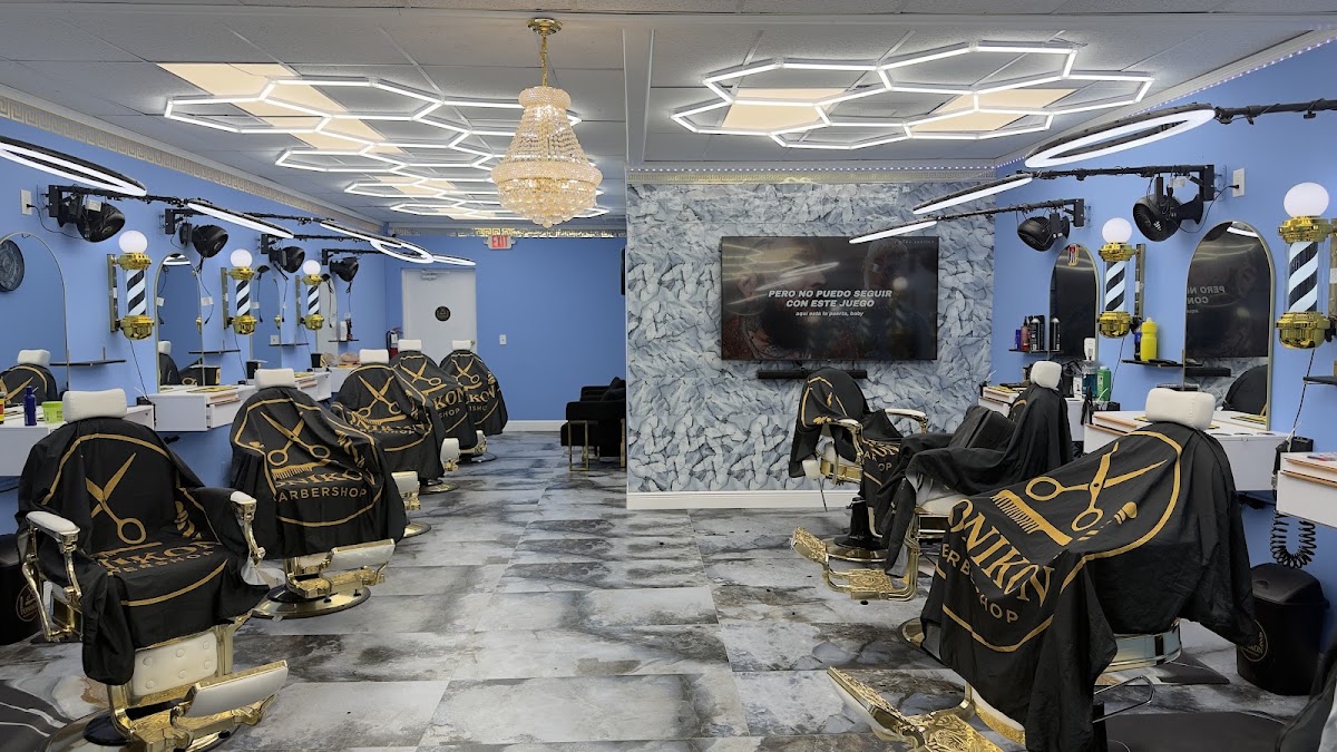 Inside Tonikon barbershop, with blue walls, gold-trimmed chairs and Tonikon capes