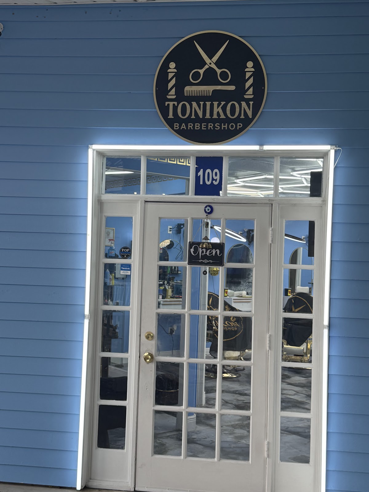 Blue storefront entrance with the Tonikon barbershop sign